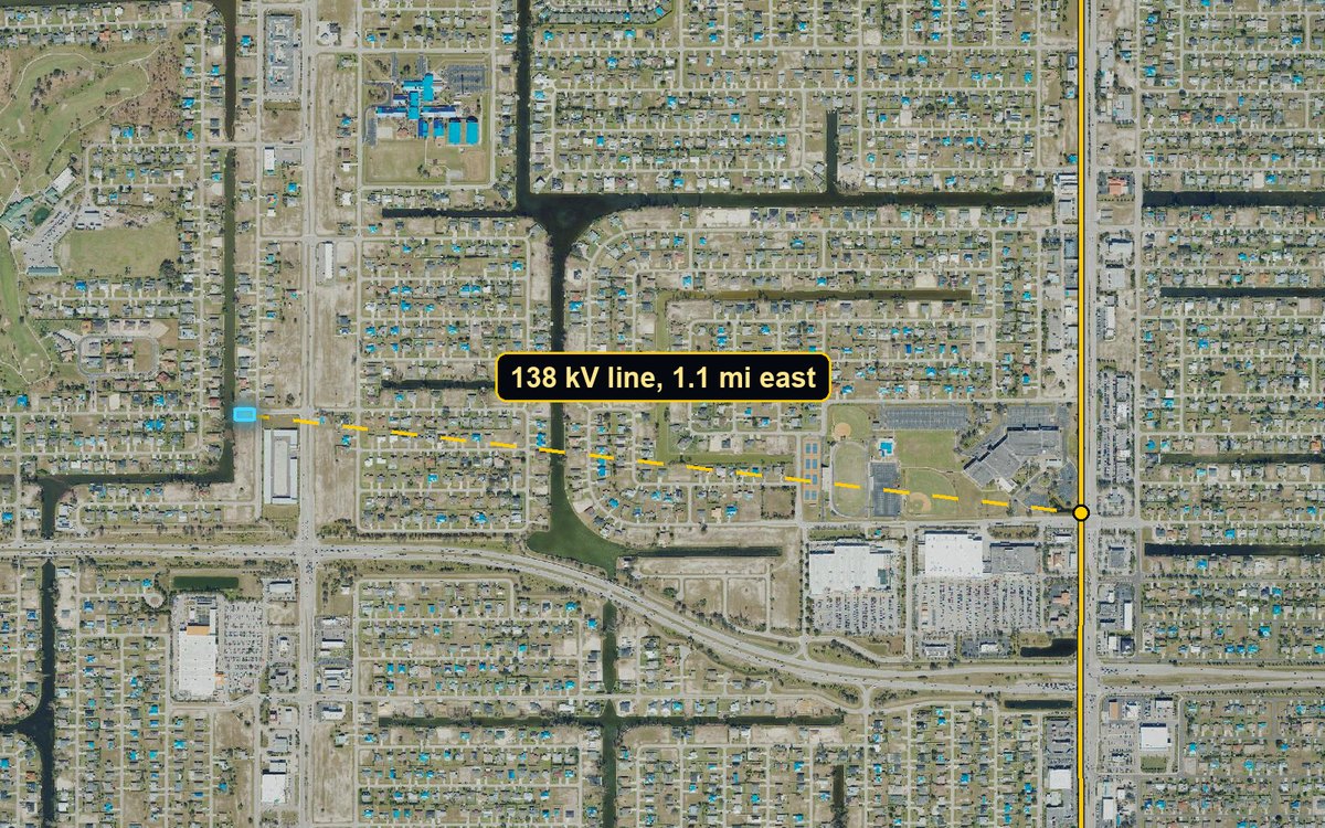 Wide aerial with a dashed line from the lot to a 138 kV power line about 1.1 miles east